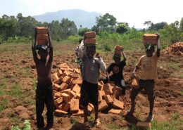 Children helping build house by carrying bricks