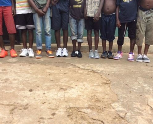 Boys showing off their new trainers donated