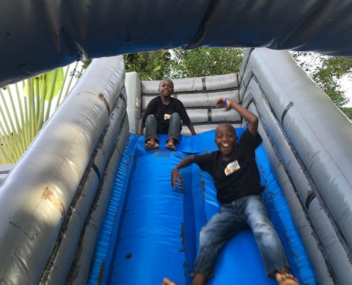 Two street children playing on a bouncy castle