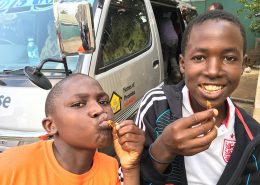 Two of the street children enjoying fried grasshoppers