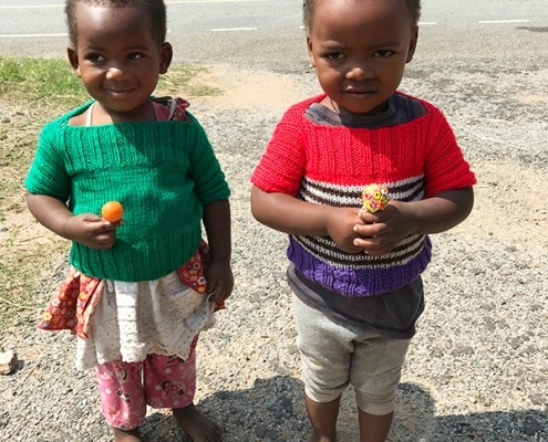 Two Ugandan children with knitted jumpers