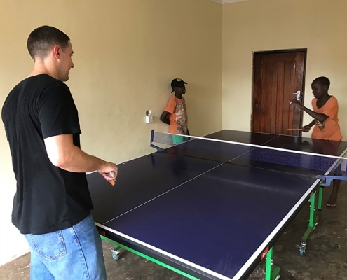 Flo playing table tennis with the boys