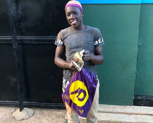 One of our street boys now working and earning money