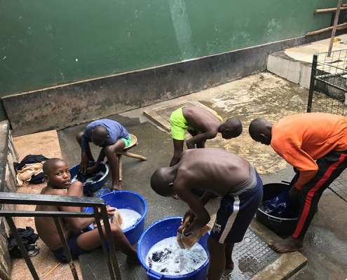 Street boys washing their school uniforms