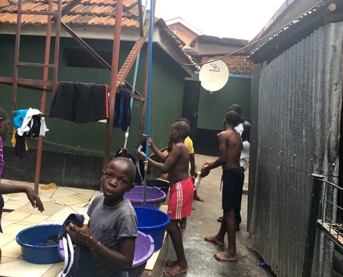 Street boys washing their school uniforms