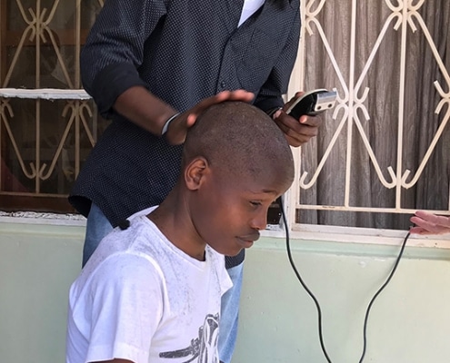 A street boy getting a haircut