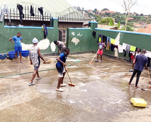 Street boys cleaning the compound