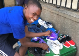 A street boy with donated shoes