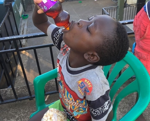 Street child with soda and popcorn
