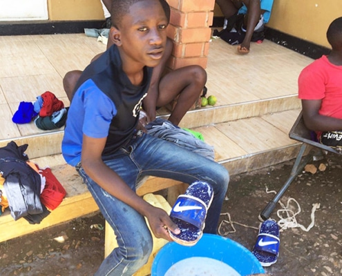 Street child cleaning his shoes