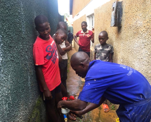 Former street boys watching the plumber