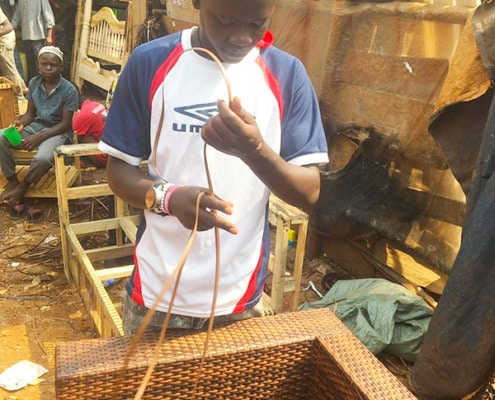 Asaph weaving plastic into chairs