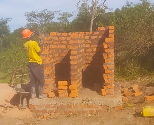 Former boy building a latrine
