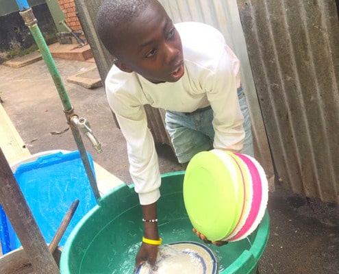 A former street child washing dishes