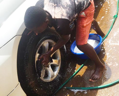 Former street boy cleaning the car