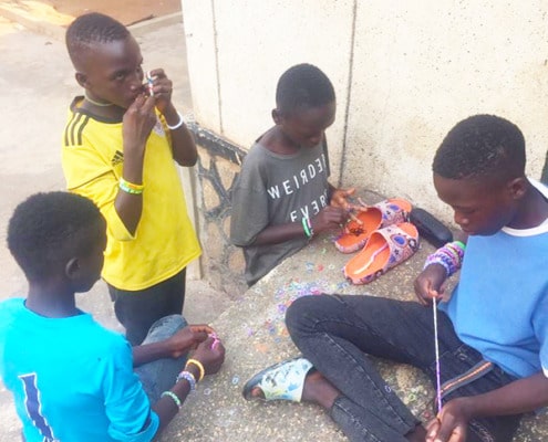 Street children making bracelets