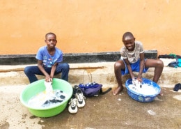 Former street children washing school uniforms