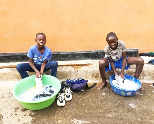 Former street children washing school uniforms