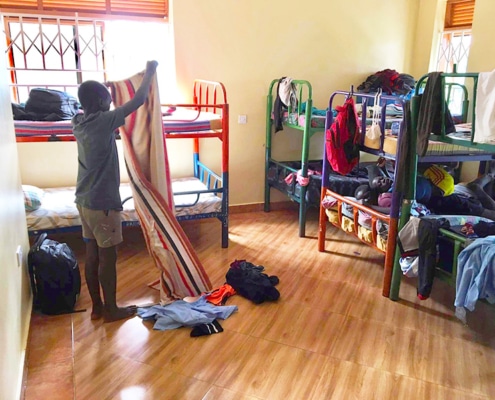 A former street child cleaning his bedroom
