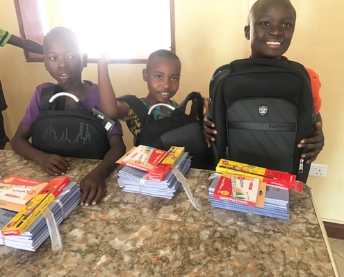Three boys preparing for school in Uganda