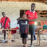 A former street child receiving a donated football shirt