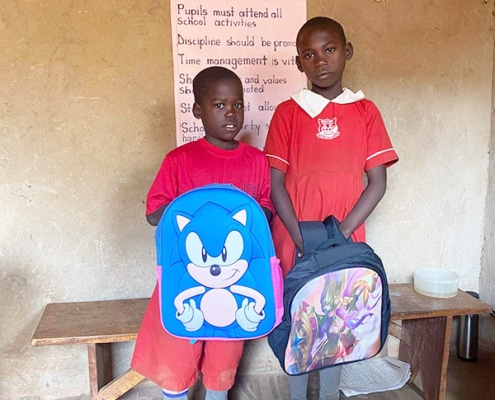 Two Ugandan children with donated school bags