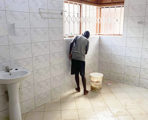 Street child now cleaning a bathroom at George's Place