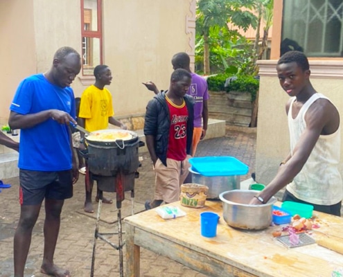 Former street boys from Kampala cooking together