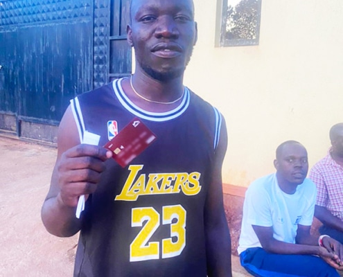 A former street boy proudly displaying his new bank card