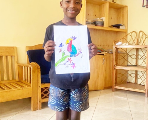 A former homeless child with his coloured drawing