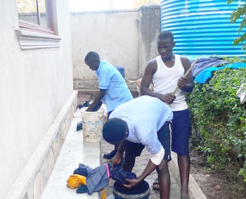 Former homeless boys washing their clothes