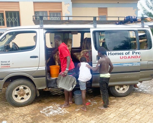 Boys helping to clean the charity mini-bus