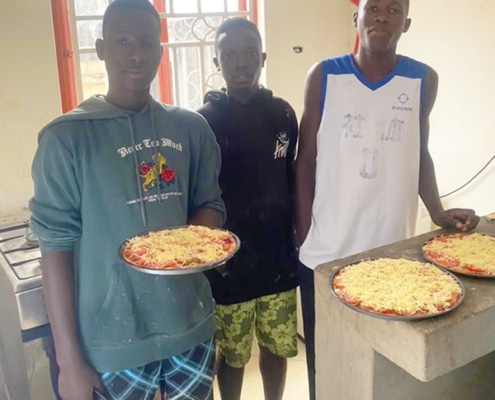 Three of the boys helping to cook at the charity