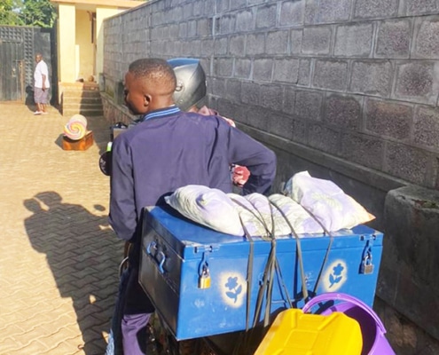 A former homeless boy going to school by boda