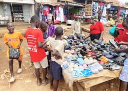 Boys buying sandals at a street market in Uganda