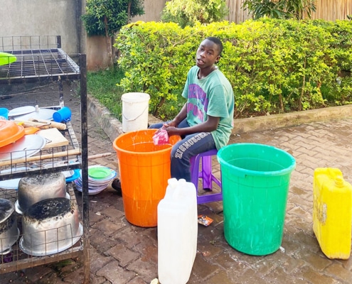 Former homeless boy washing up dishes